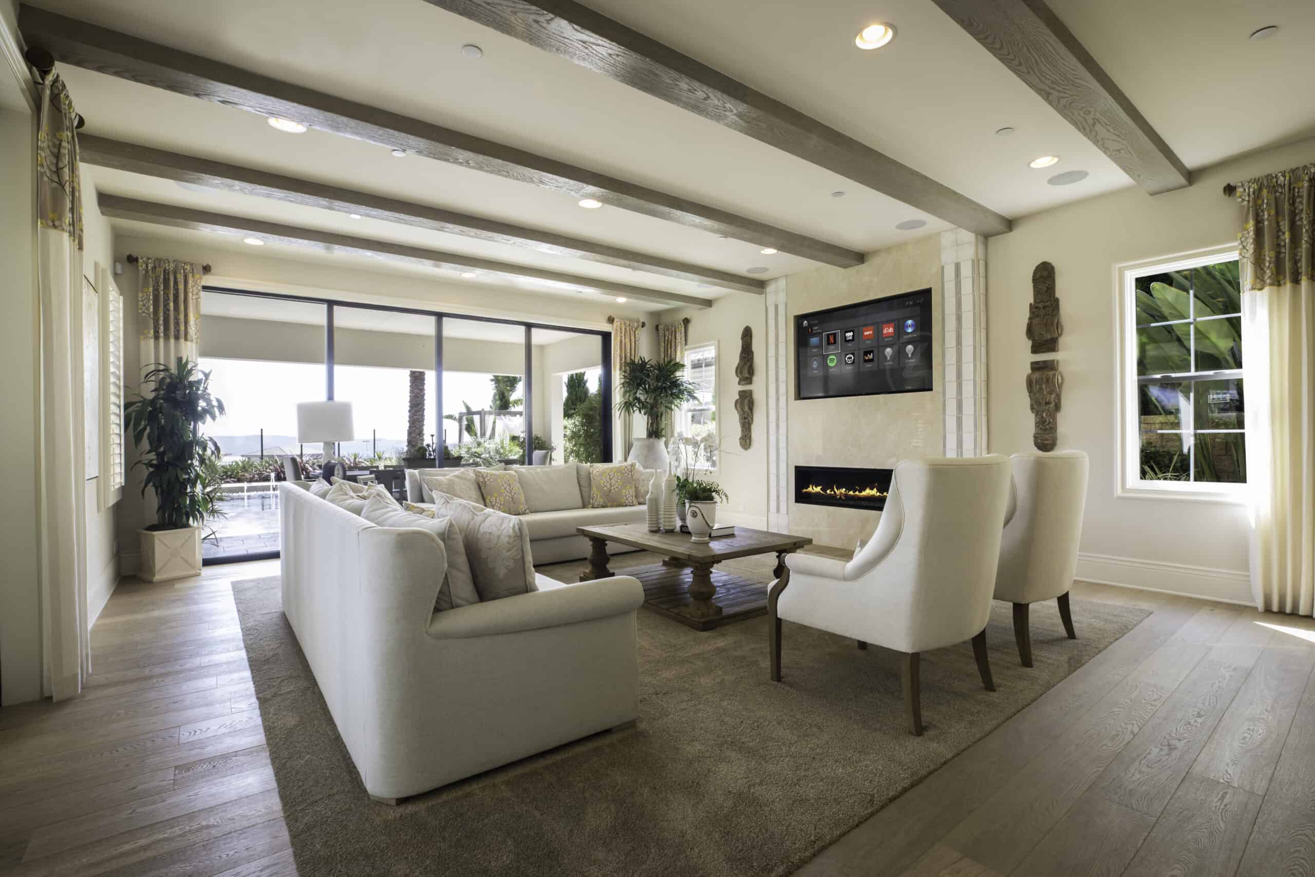 A living room with white furniture and a fireplace equipped with audio capabilities for multi-room entertainment.