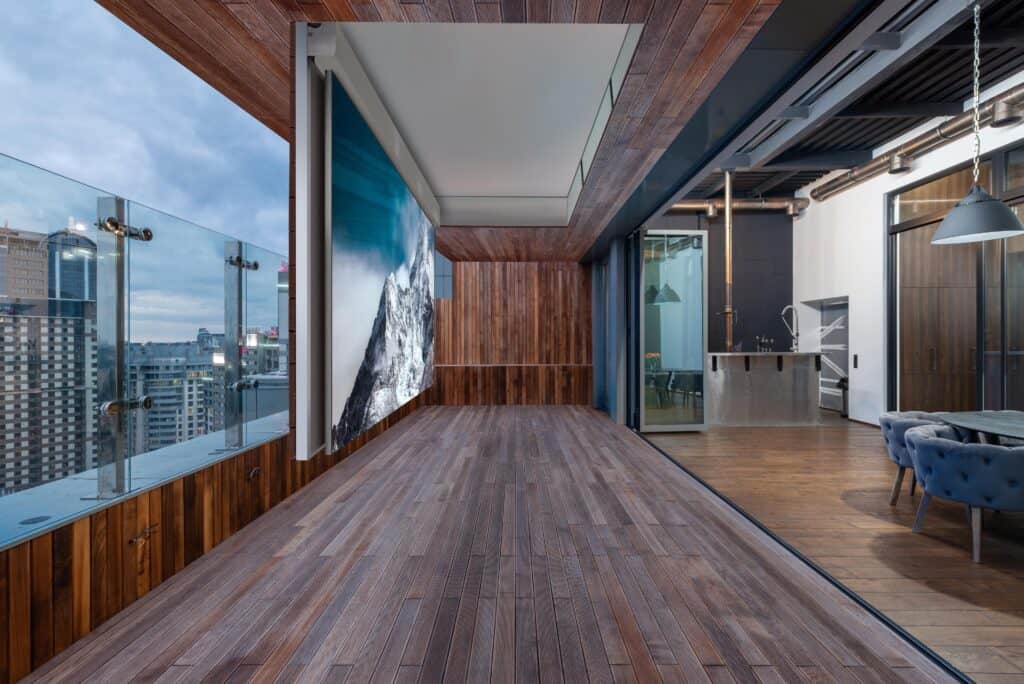 A technologically advanced office with a wooden floor and a view of the city, equipped with smart home installation.
