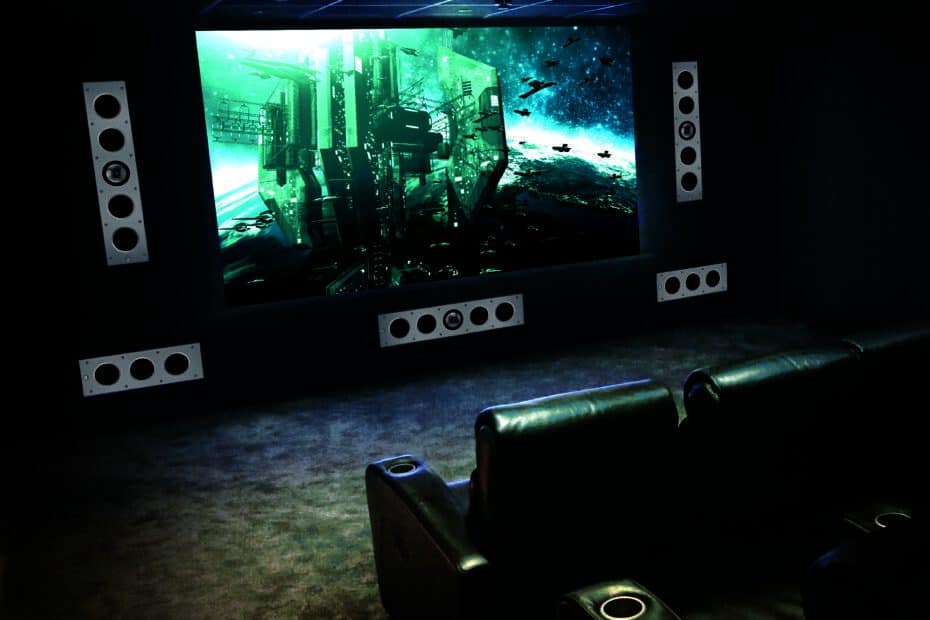 A home theater room with a large screen and KEF speakers.